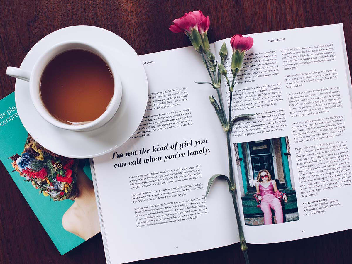 An open book with a coffee mug keeping the pages open