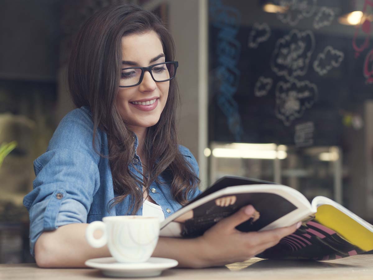 A woman smiling while holding an open book