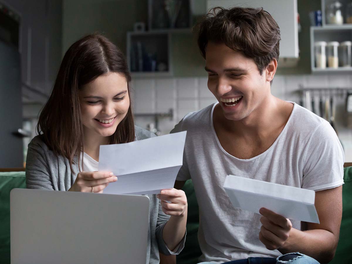 A couple opening mail together and laughing